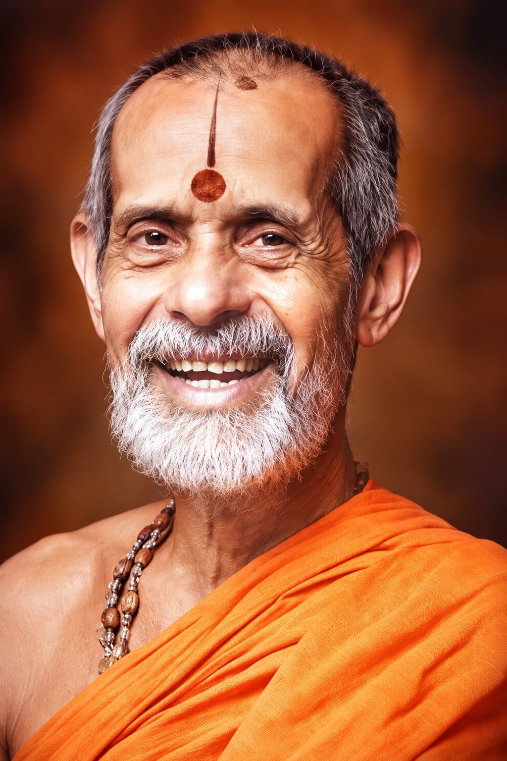 Portrait of Sri Vishwesha Theertha Swamiji, smiling, in saffron robes